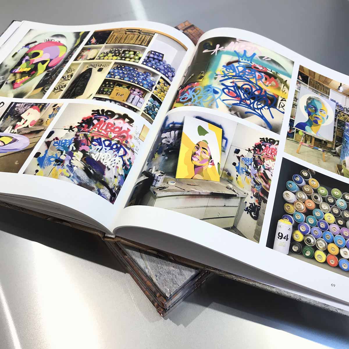 Livre ouvert de l'artiste Alber avec des photos d'atelier street art